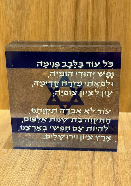 Decorative plaque with Star of David and Hebrew text on a wooden background